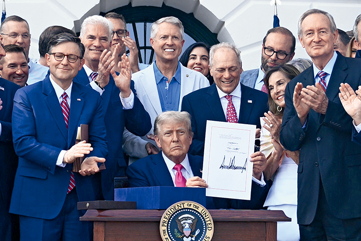2025年7月4日，在美国首都华盛顿白宫，美国总统特朗（中）展示法案上的签名 新华社/法新