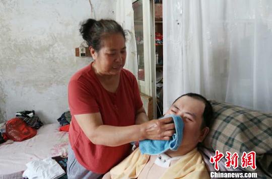 每次喂完食物后,梁青蘭都要仔細(xì)地幫兒子清理干凈。 尚明俠 攝