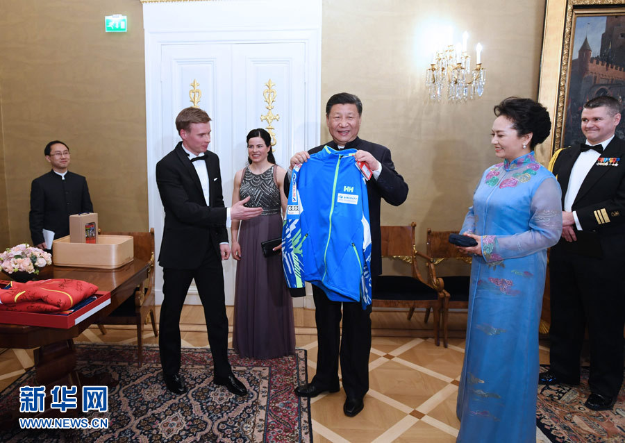 當地時間4月5日晚，國家主席習近平和芬蘭總統尼尼斯托在赫爾辛基共同會見剛剛參加完2017年世界花樣滑冰錦標賽的中芬兩國冰雪運動員代表。習近平夫人彭麗媛和尼尼斯托夫人豪吉歐參加會見。這是芬蘭運動員向習近平和夫人彭麗媛贈送運動衣。新華社記者 饒愛民 攝