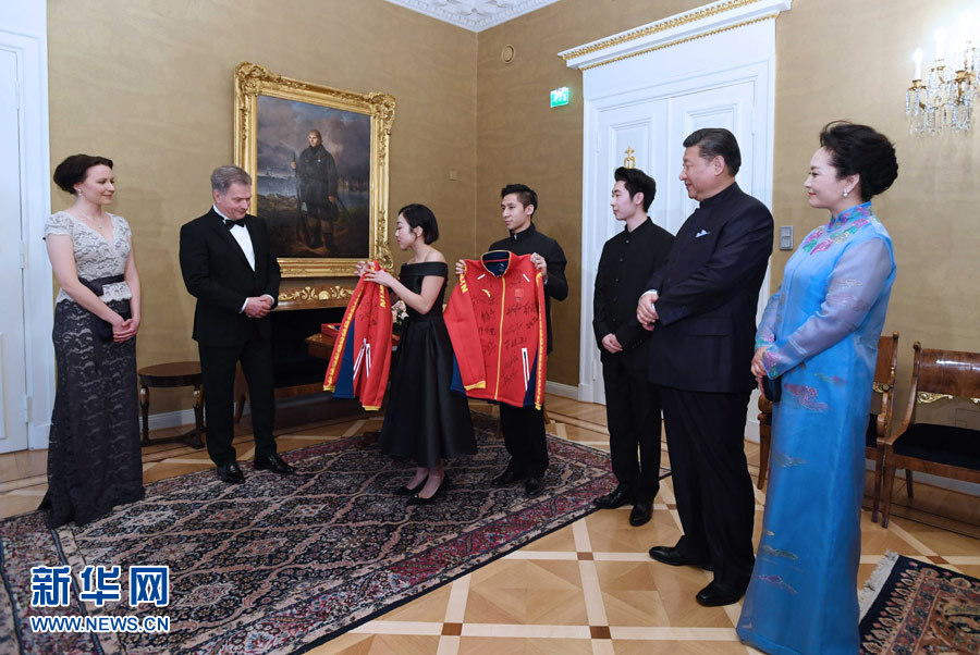 當地時間4月5日晚，國家主席習近平和芬蘭總統尼尼斯托在赫爾辛基共同會見剛剛參加完2017年世界花樣滑冰錦標賽的中芬兩國冰雪運動員代表。習近平夫人彭麗媛和尼尼斯托夫人豪吉歐參加會見。這是中國運動員向尼尼斯托和夫人豪吉歐贈送運動衣。新華社記者 饒愛民 攝